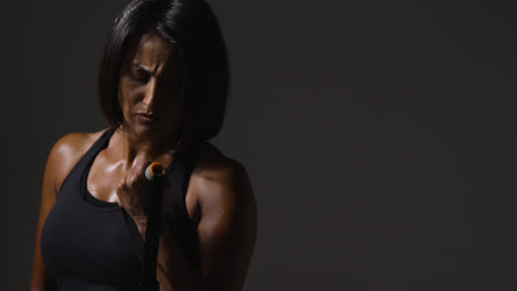 Close-Up-Studio-Shot-Of-Mature-Woman-Wearing-Gym-Fitness-Clothing-Exercising-With-Resistance-Band-3